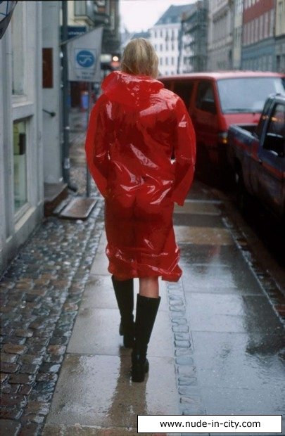 Пышногрудая блондинка гуляет по городу в красном дождевике на голом теле, а потом и вовсе снимает его